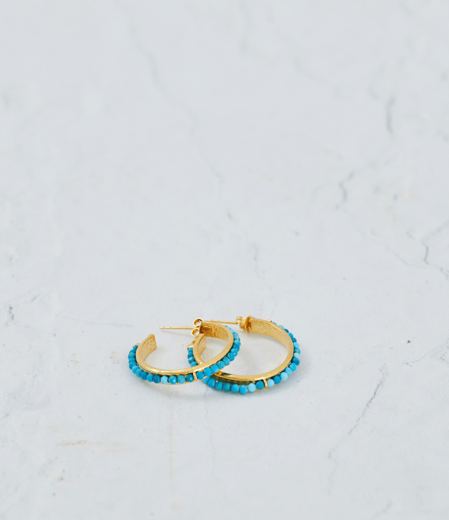 Turquoise hoop earrings made with beads and 18k gold plated sterling silver hoops, showcasing elegant craftsmanship.