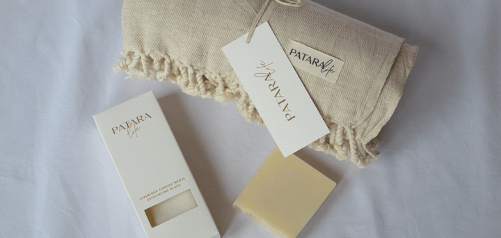 A folded Peshtemal with olive oil soap and exfoliating glove as a gift bundle