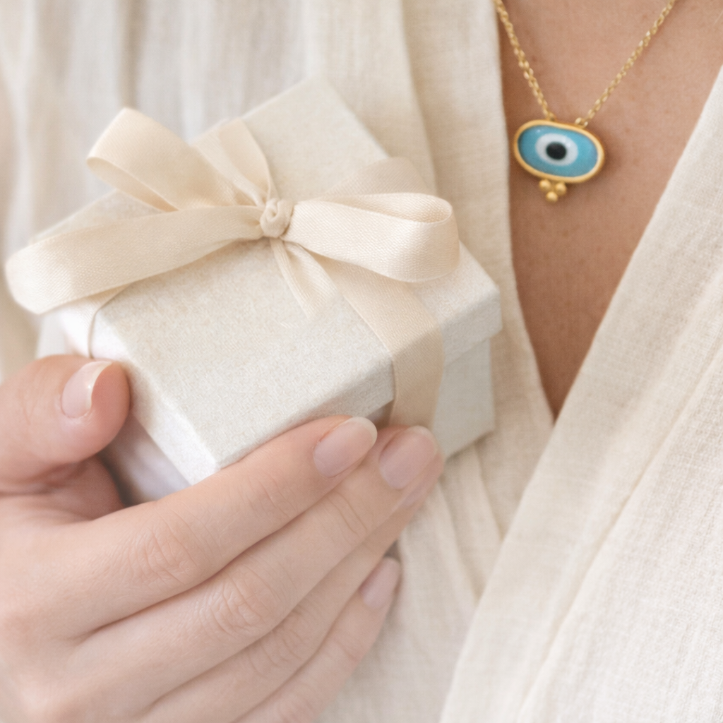 Evil eye jewellery gift idea featuring gold evil eye necklace and wrapped gift box, symbolising protection and meaningful gifting