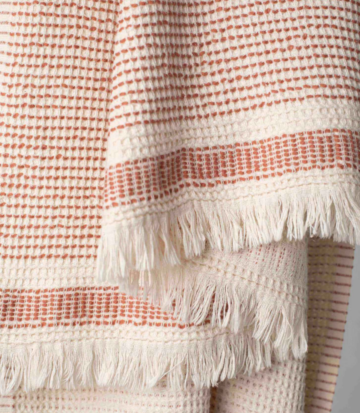 a Turkish beach towel with copper dots and creme tassles