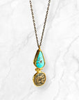 Turquoise coin necklace featuring an ancient Roman coin and a diamond-shaped turquoise stone on a silver chain.