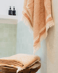 A "Kalkan" beach towel hanging in bathroom and another folded on top of stool