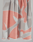 Turkish beach towel in coral and gray patterned with fringed edges