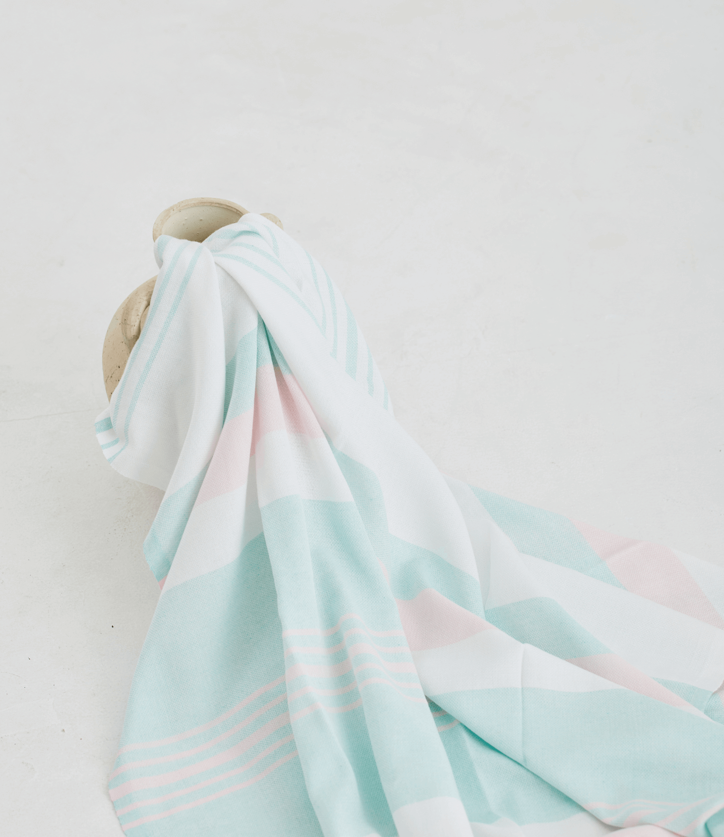 A lightweight peshtemal towel in light pink and mint