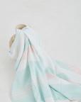 A lightweight peshtemal towel in light pink and mint