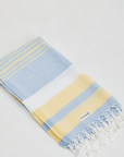 A lightweight peshtemal towel in light yellow & blue