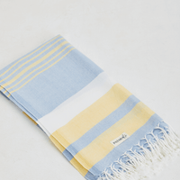 A lightweight peshtemal towel in light yellow & blue