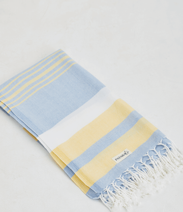 A lightweight peshtemal towel in light yellow & blue