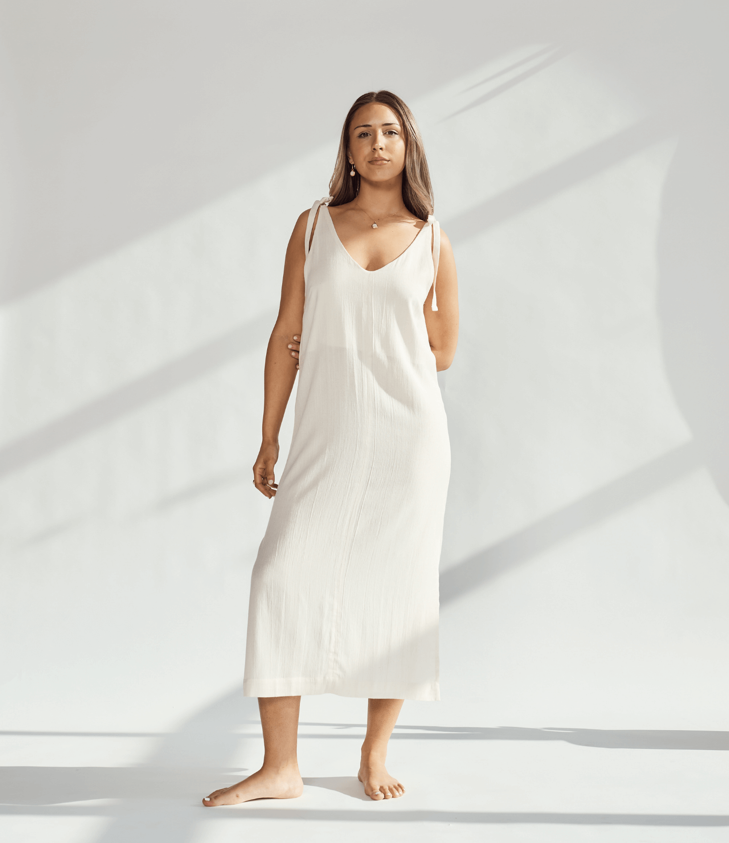 Soft cotton dress with tied straps, showcasing elegant design and breathable fabric for comfortable wear.