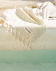 Kas Linen/Cotton peshtemal draped over a pool edge, showcasing its soft texture and PATARA label.