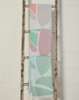 Pastel Coloured Turkish Beach Towels showcasing leaf patterns hanging on a rustic ladder.