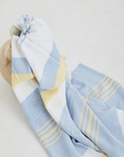 A lightweight peshtemal towel in light yellow and blue