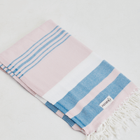 A lightweight peshtemal towel in light pink and blue