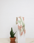 "Patara" Peshtemal in Color: Green & Red draped on a pedestal
