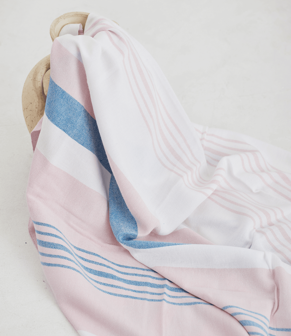 A lightweight peshtemal towel in light pink and blue