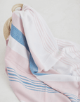 A lightweight peshtemal towel in light pink and blue