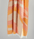 Striped orange and beige towel with white fringe on a gray background