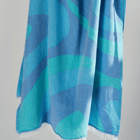 Turkish Beach Towel with an abstract wave design in shades of blue and turquoise, showcasing a vibrant coastal aesthetic.