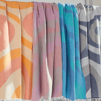 Collection Turkish Beach Towels in vibrant colors and abstract wave designs, showcasing Turkish Cotton fabric.