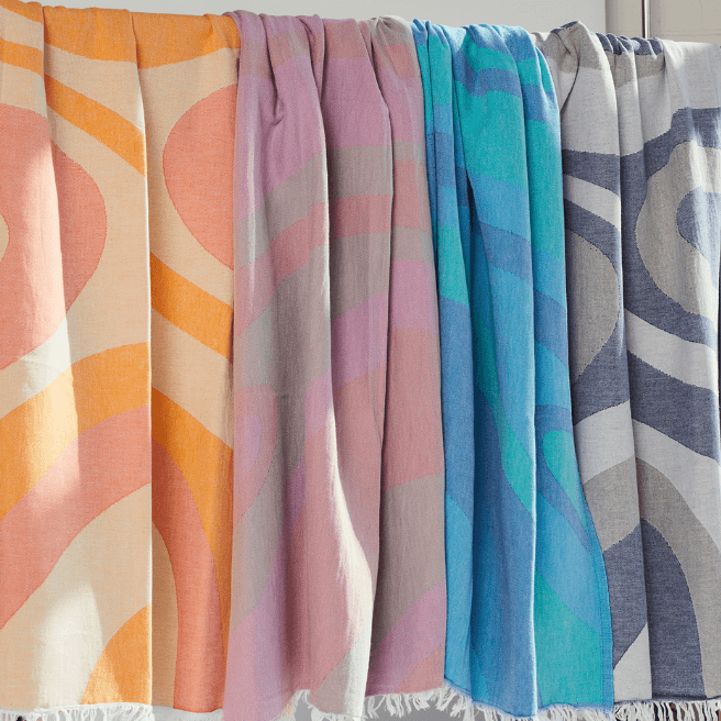 Collection Turkish Beach Towels in vibrant colors and abstract wave designs, showcasing Turkish Cotton fabric.