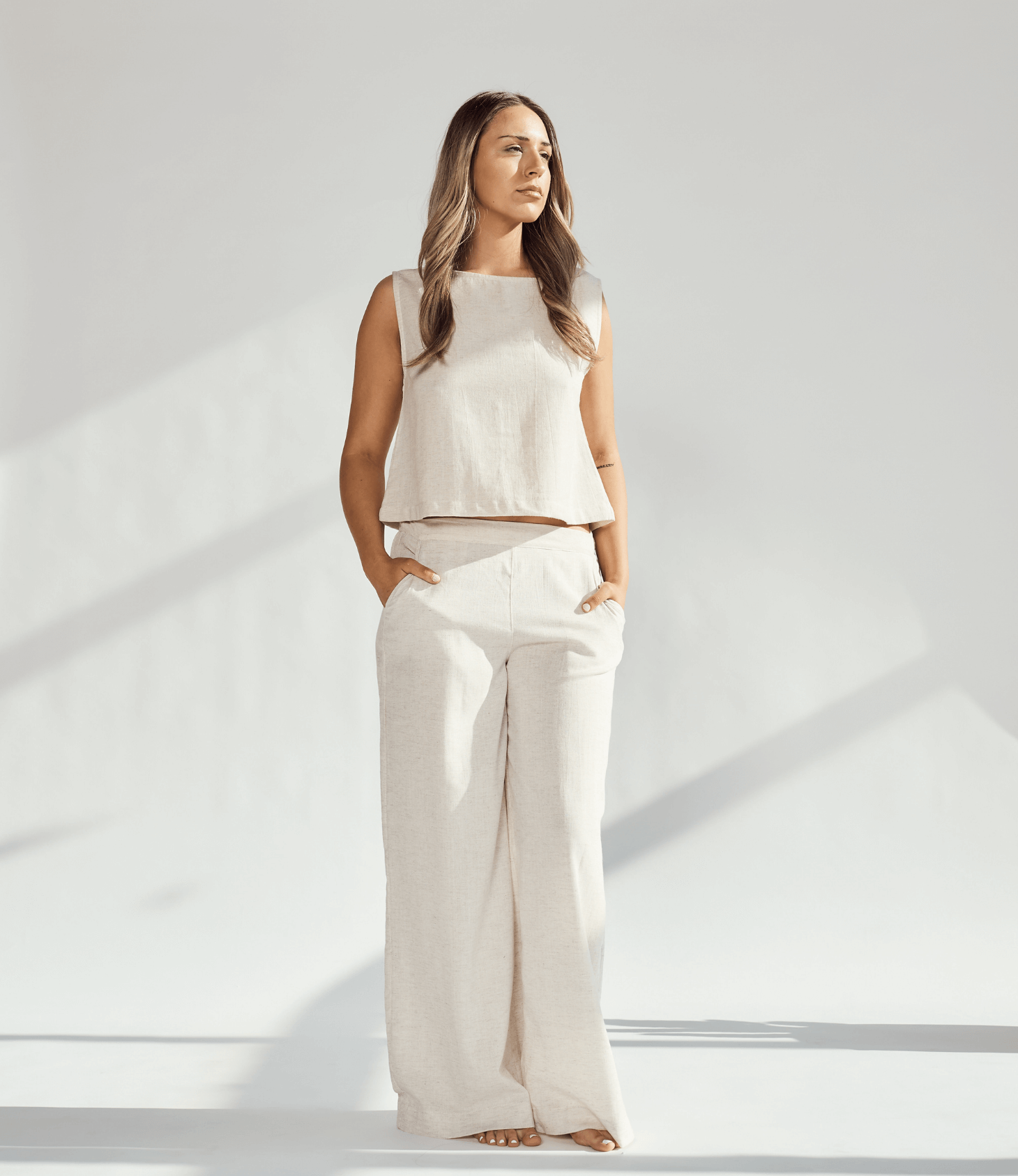 Model wearing elegant linen wide leg pants paired with a matching top in a soft neutral tone, showcasing a relaxed silhouette.
