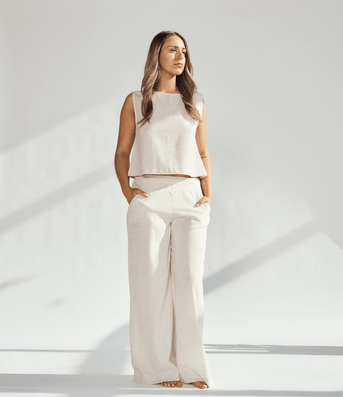 Model wearing elegant linen wide leg pants paired with a matching top in a soft neutral tone, showcasing a relaxed silhouette.