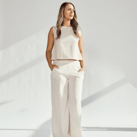 Model wearing elegant linen wide leg pants paired with a matching top in a soft neutral tone, showcasing a relaxed silhouette.