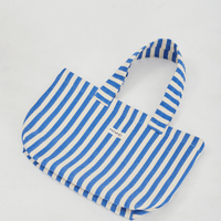 Herringbone woven linen tote bag in Blue stripe layed flat on floor