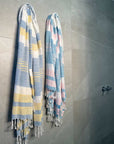 Two lightweight peshtemal towels hanging on bathroom wall
