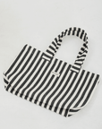 Herringbone woven linen tote bag in Black stripe layed flat on floor