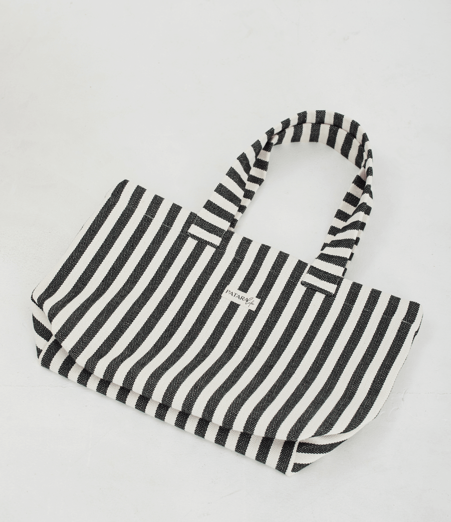 Herringbone woven linen tote bag in Black stripe layed flat on floor