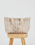 Herringbone woven linen tote bag in Color: Light Brown stripe on top of stool