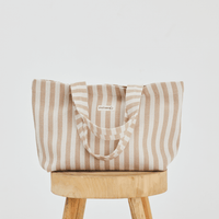 Herringbone woven linen tote bag in Color: Light Brown stripe on top of stool