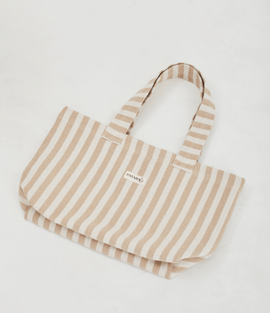 Herringbone woven linen tote bag in Light Brown stripe layed flat on floor