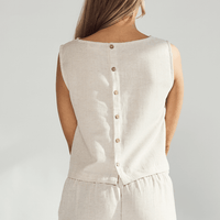 Back view of a woman's linen crop top featuring button details and a relaxed fit.