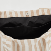 Inside look at Herringbone woven linen tote bag showing black lining and pockets