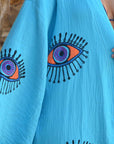 Evil Eye Kaftan Robe in turquoise featuring hand-painted eye designs, perfect for stylish loungewear or beachwear.