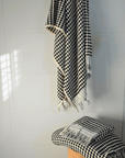 Black and white checkered Turkish cotton bath towel draped and folded, showcasing luxurious texture and design.