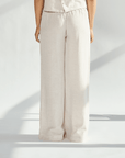 Back view of elegant linen wide leg pants in light beige, showcasing a flowing silhouette and comfortable fit.