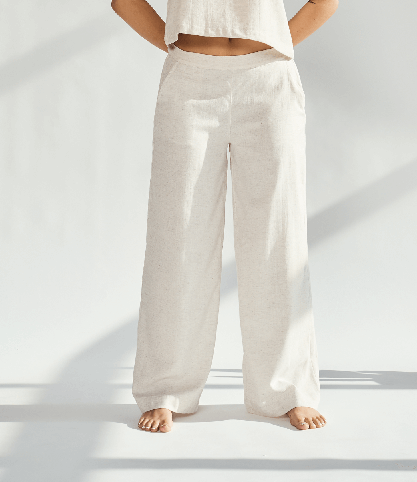 Linen wide leg pants in a light beige color, offering a relaxed fit and graceful silhouette for sophisticated style.