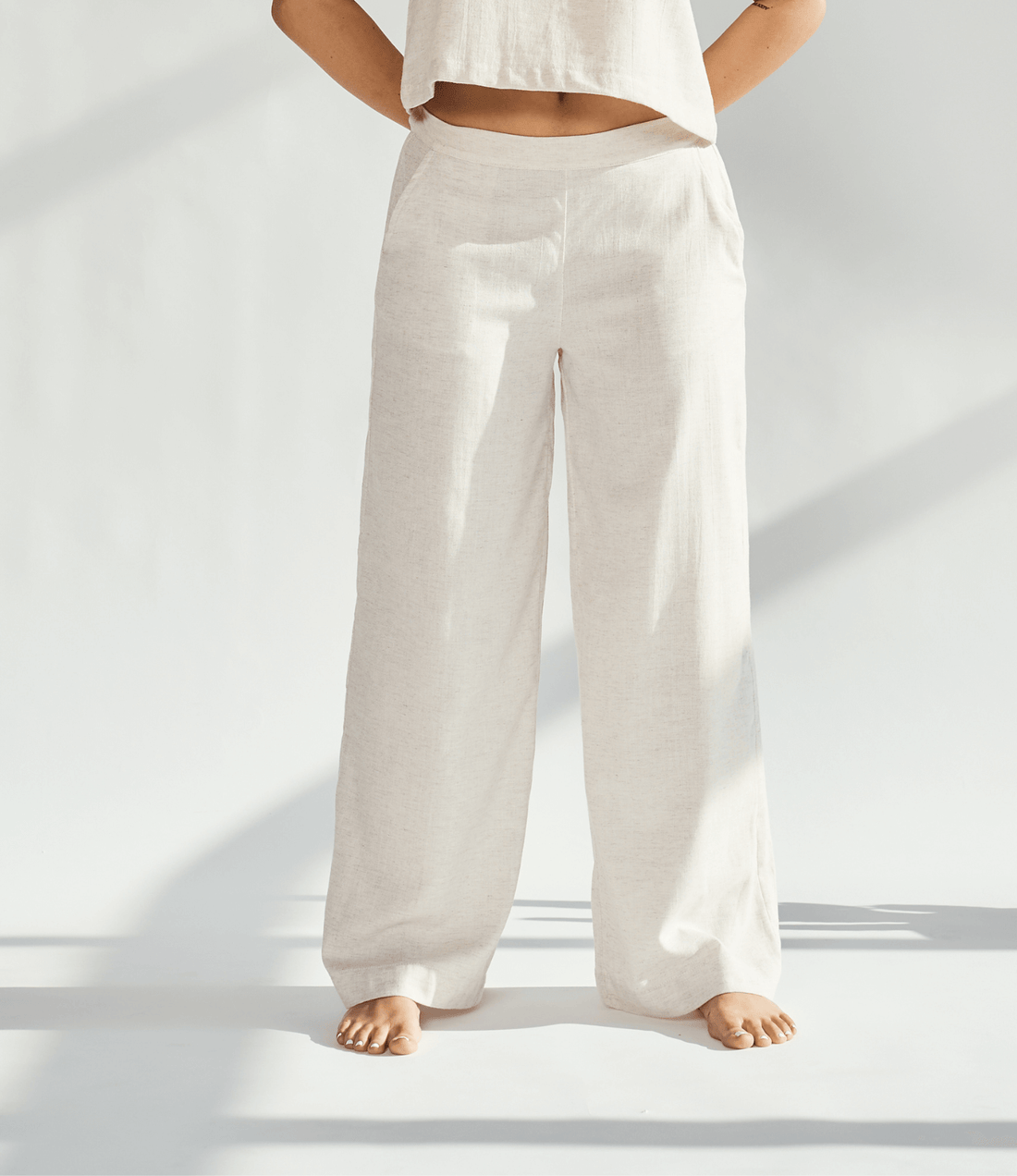 Linen wide leg pants in a light beige color, offering a relaxed fit and graceful silhouette for sophisticated style.