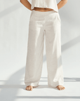Linen wide leg pants in a light beige color, offering a relaxed fit and graceful silhouette for sophisticated style.