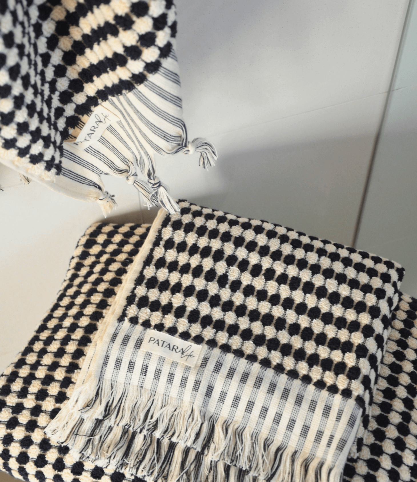Pearl Turkish cotton hand towel in black and white, featuring traditional knotting techniques for a luxurious feel.