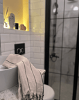 A premium linen "Kekova" Turkish towel folded and draped over sink