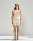 Woman wearing a matching top and shorts set on a plain background