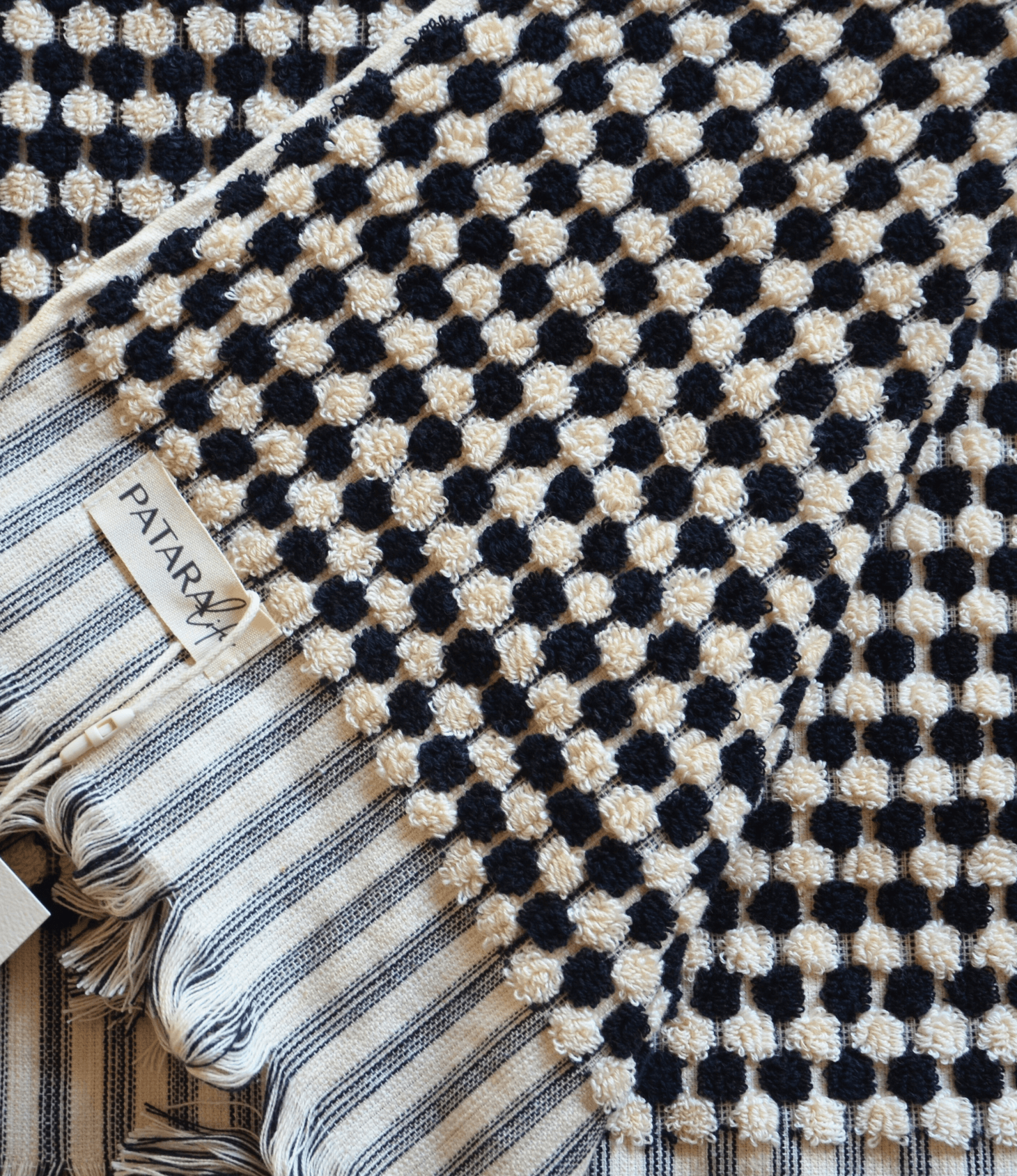 Close-up of black and white Turkish cotton bath towel featuring artisanal dot patterns, showcasing luxurious texture and design.