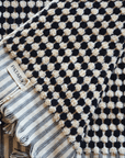Close-up of black and white Turkish cotton bath towel featuring artisanal dot patterns, showcasing luxurious texture and design.