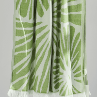 Radiance Turkish Beach Towel featuring a green sunburst pattern, made from soft organic cotton with fringe detail.