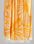 Radiance Turkish beach towel featuring a sunburst pattern in golden yellow and soft orange hues.