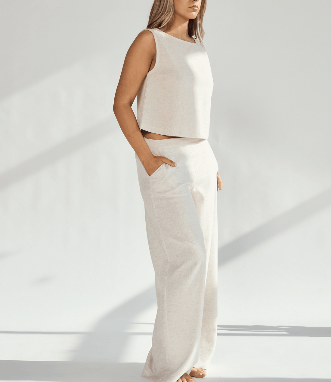 Woman wearing a stylish linen wide leg and crop top set, showcasing a comfortable fit and practical pockets.